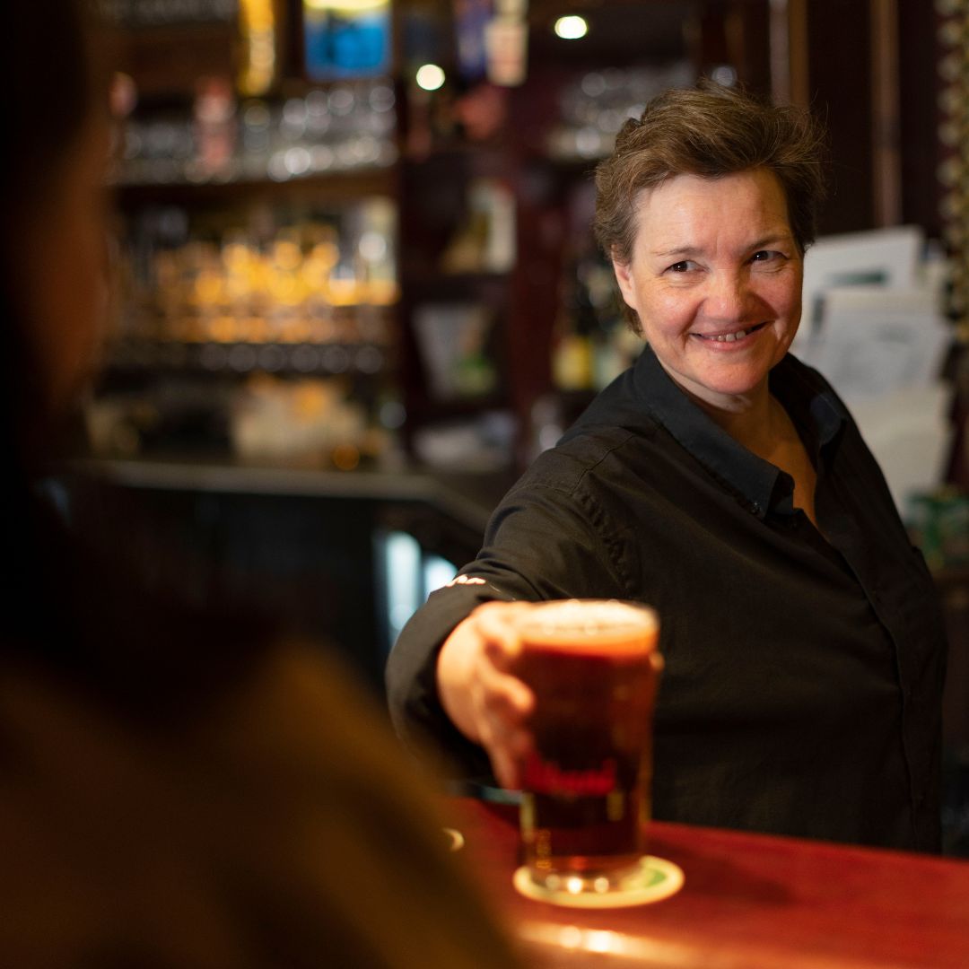 bartender på Amagerhylden rækker en fadøl til en kunde